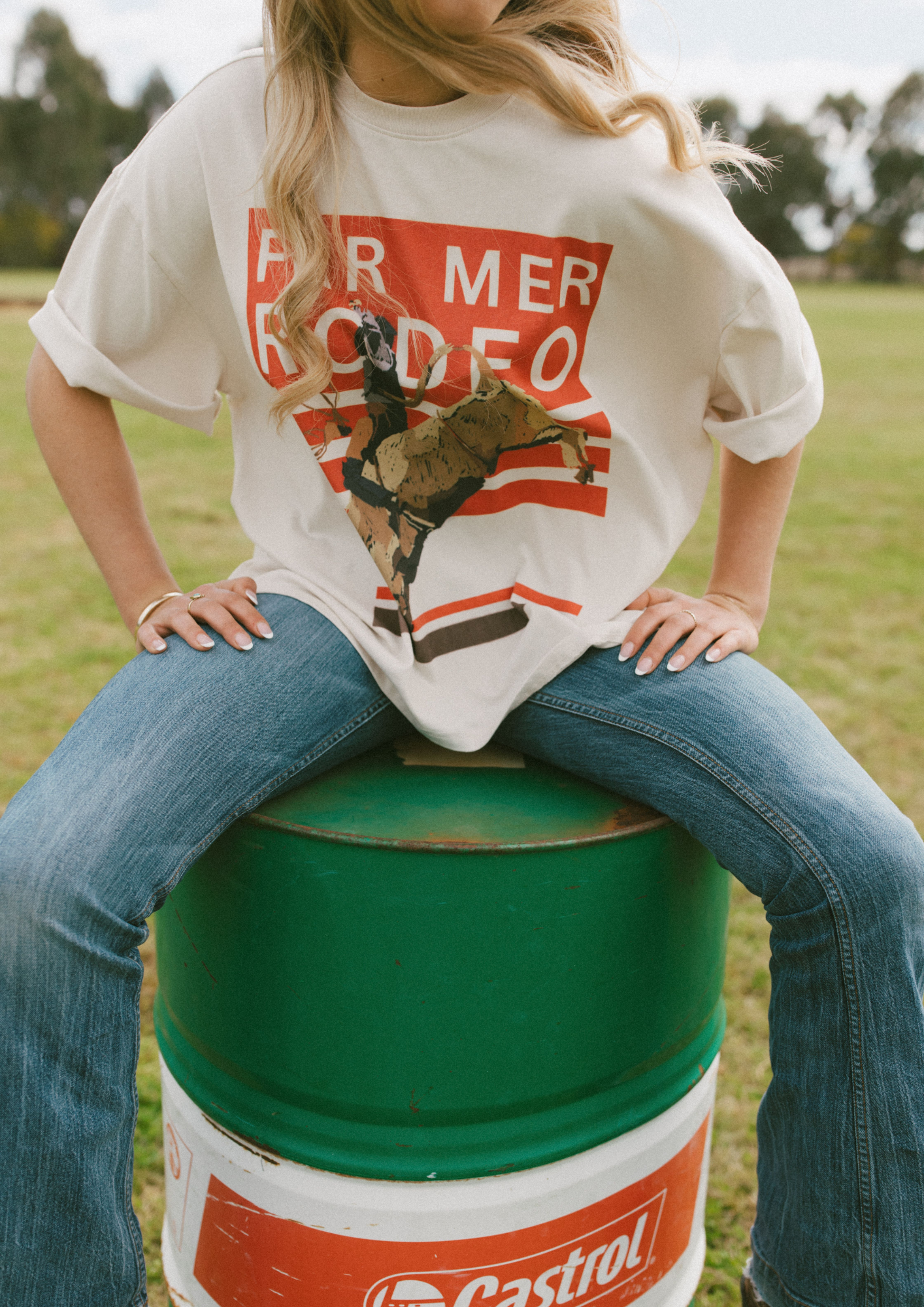 Close-up front view of Rodeo Box Tee displaying orange striped background with rodeo bull rider print