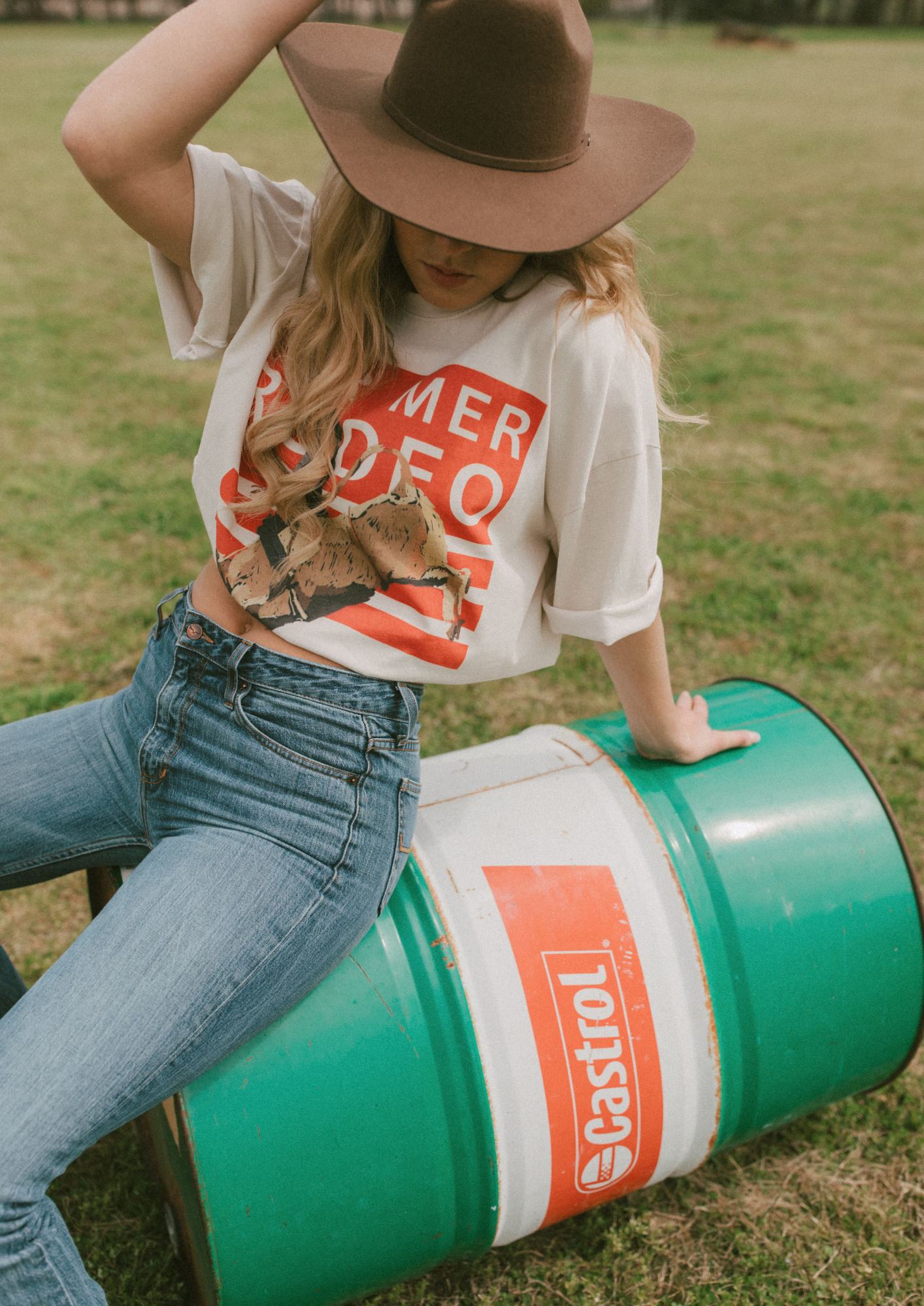 Three-quarter view of Rodeo Box Tee featuring orange rodeo graphic and relaxed fit short sleeves