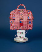 Front view of Fable lunch tote with pink floral and red gingham pattern on blue background