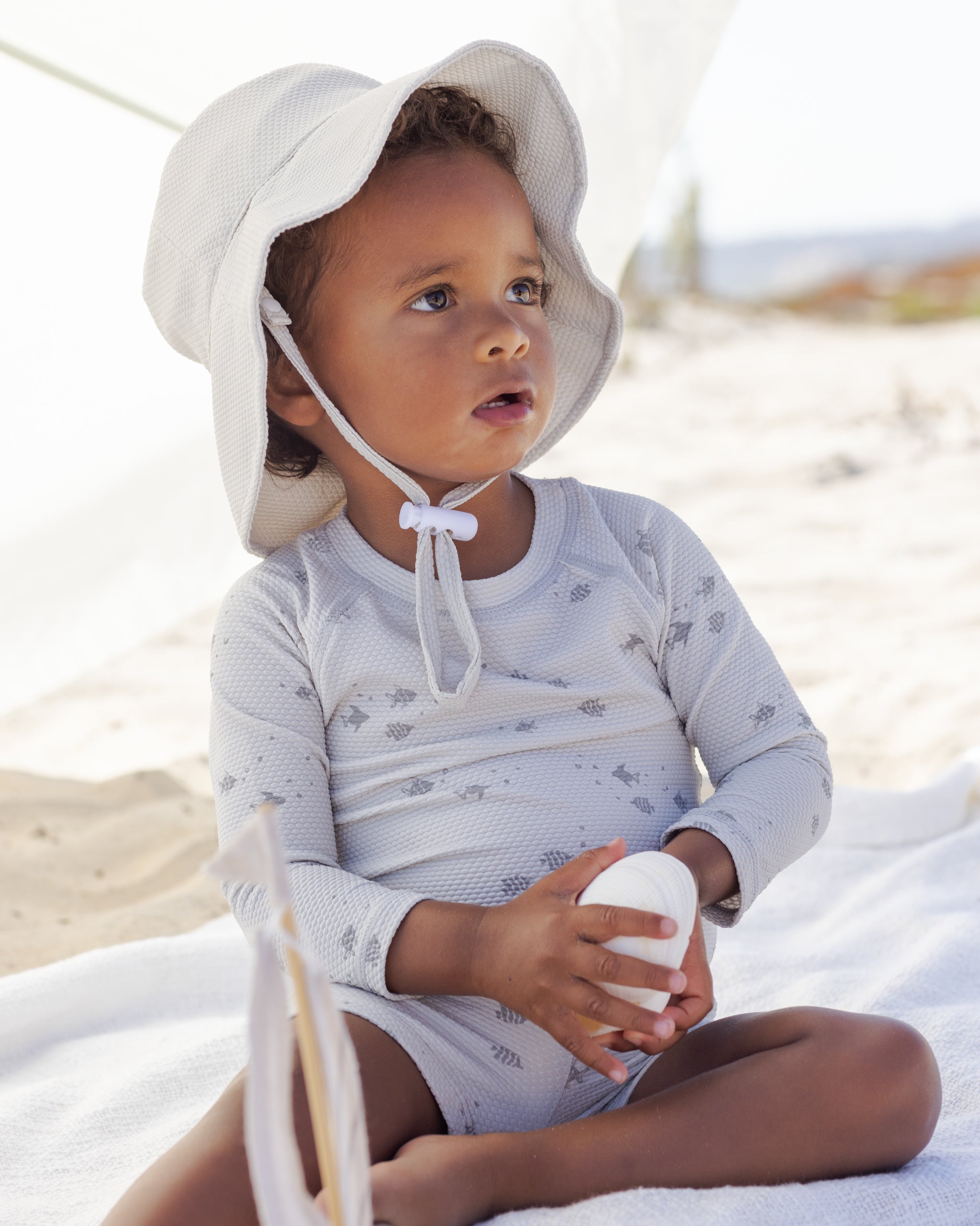 Young boy wearing the Finn Rashguard + Short Set Fish | Quincy Mae