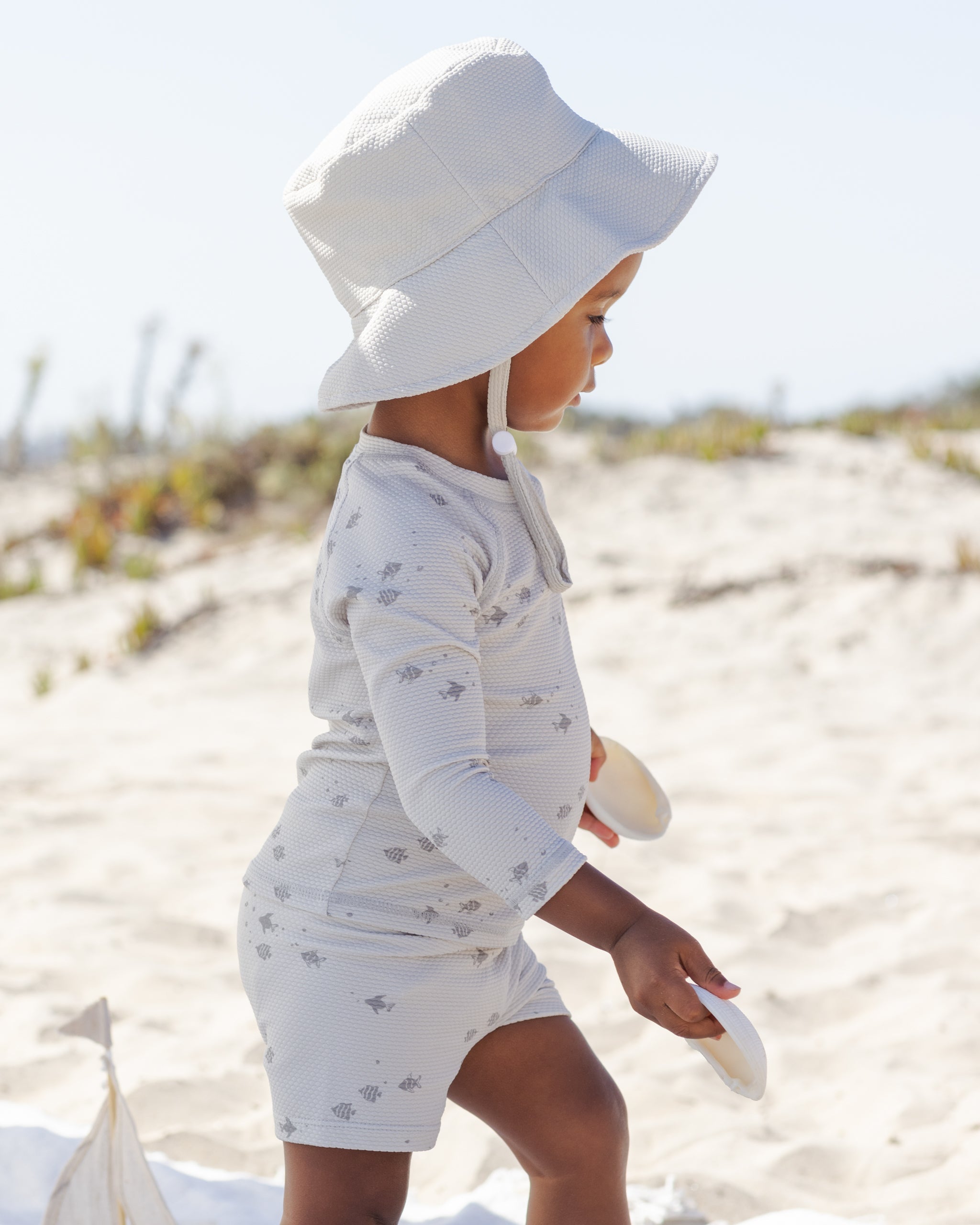 Side view of toddler in the Finn Rashguard + Short Set Fish | Quincy Mae
