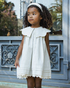 Child modeling Florence Dress Sky Stripe outdoors showing eyelet hem detail