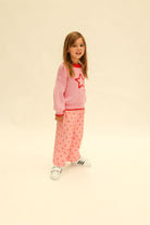 Three quarter view of pink Fruit Loop Pants Hearts showing heart pattern and loose comfortable fit