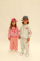 Pink heart print Fruit Loop Pants styled with matching pink sweater in full outfit view
