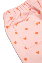 Close up detail of pink ribbed waistband and red heart print on Fruit Loop Pants Hearts
