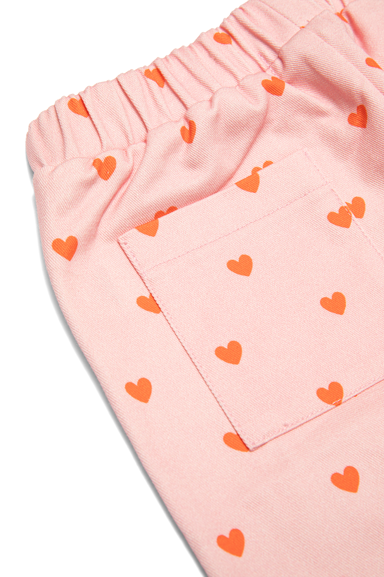 Close up detail of pink ribbed waistband and red heart print on Fruit Loop Pants Hearts