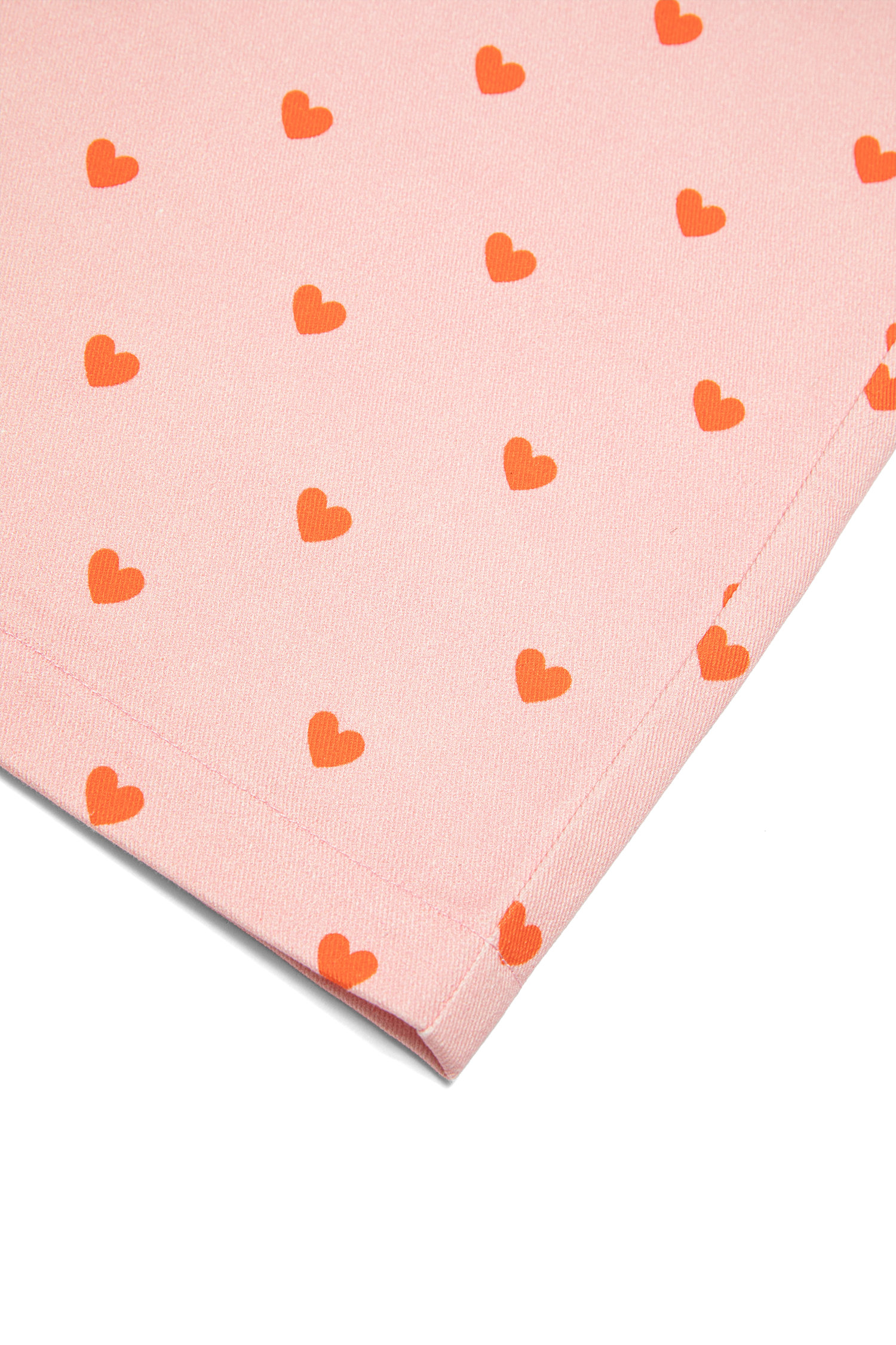 Macro detail shot of red heart print pattern on pink Fruit Loop Pants fabric