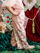 Child wearing a pink outfit with floral pants by Fleur Harris - "Garden of Dreams" Meadow Pant - Pink by Fleur Harris