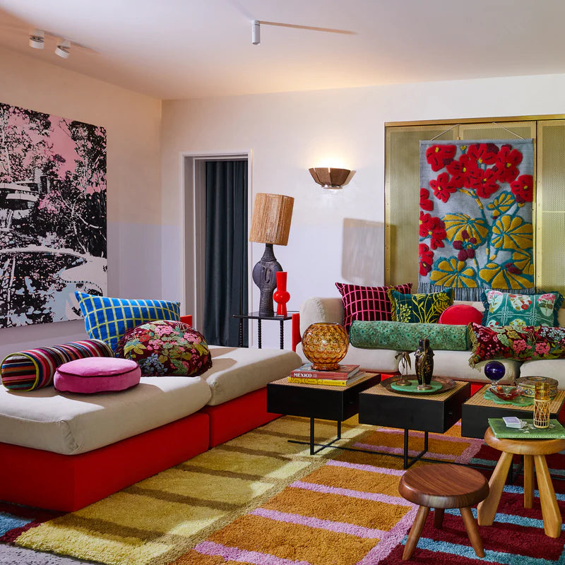 Colorful living room with a sectional sofa, coffee table, and decorative Sage & Clare pillows.