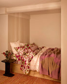 Geometric Pink Mohair Throw draped over wooden bed frame in cozy bedroom setting