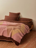 Close-up of Geometric Pink Mohair Throw showing diagonal color block pattern on bed