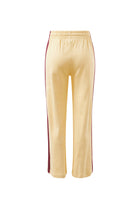Woman in bright green wide leg track pants with blue side stripe styled with white sweatshirt