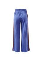 Back view of vintage blue terry trackpants displaying wide leg cut and burgundy side stripe