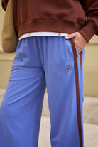 Close-up of vintage blue terry trackpants showing side pocket and burgundy stripe detail