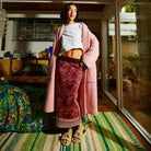 Full body styling shot of Hanna Knit Maxi Skirt with pink cardigan in modern interior setting