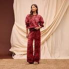 Front view of red Hanna knit pants with geometric pattern and Greek key side stripe detail