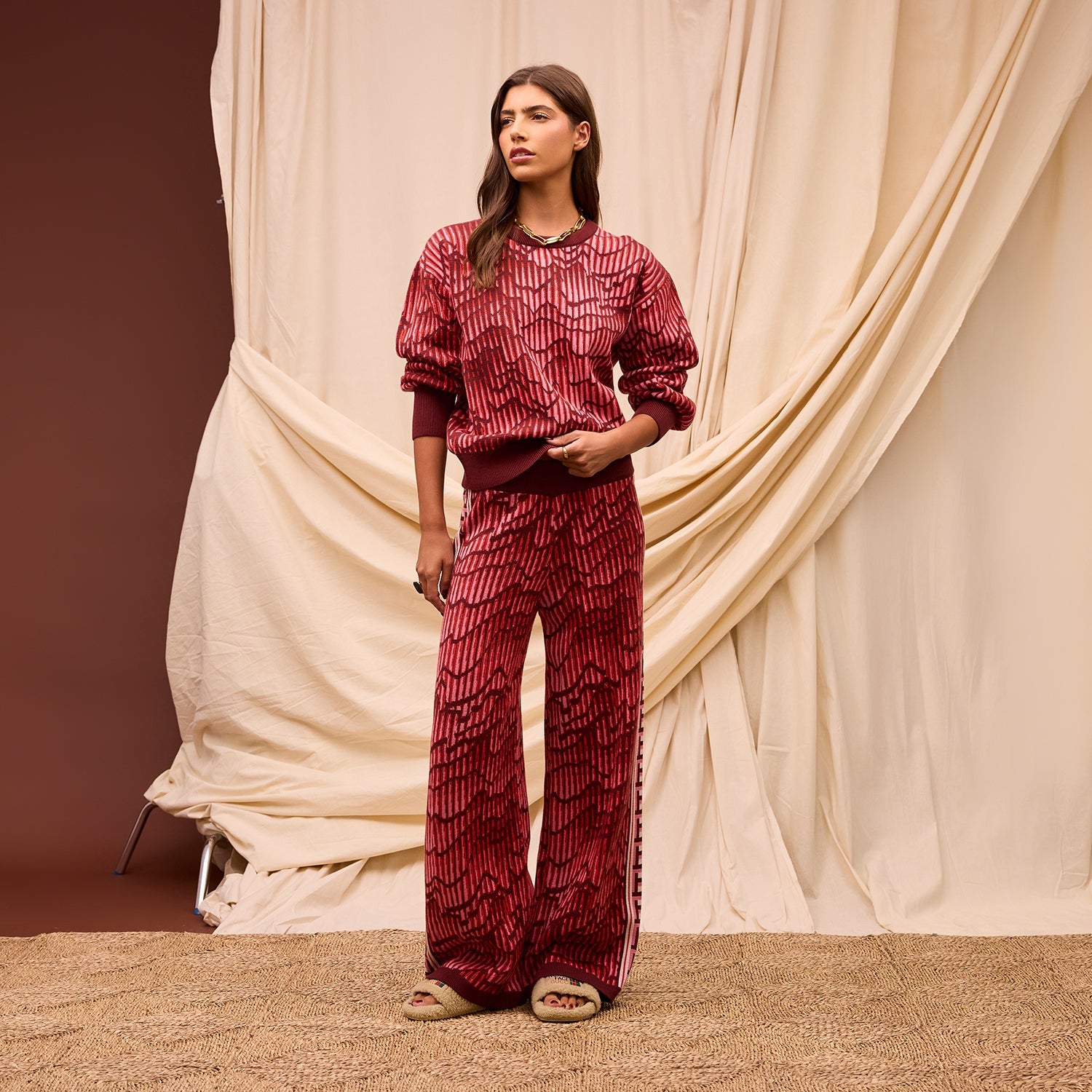 Front view of red Hanna knit pants with geometric pattern and Greek key side stripe detail