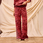 Close-up front view showing wide leg silhouette and geometric texture of red Hanna knit pants