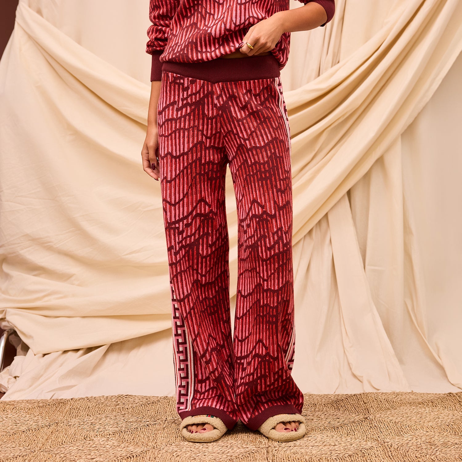 Close-up front view showing wide leg silhouette and geometric texture of red Hanna knit pants
