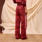 Back view of red Hanna knit pants highlighting geometric pattern and Greek key stripe down leg