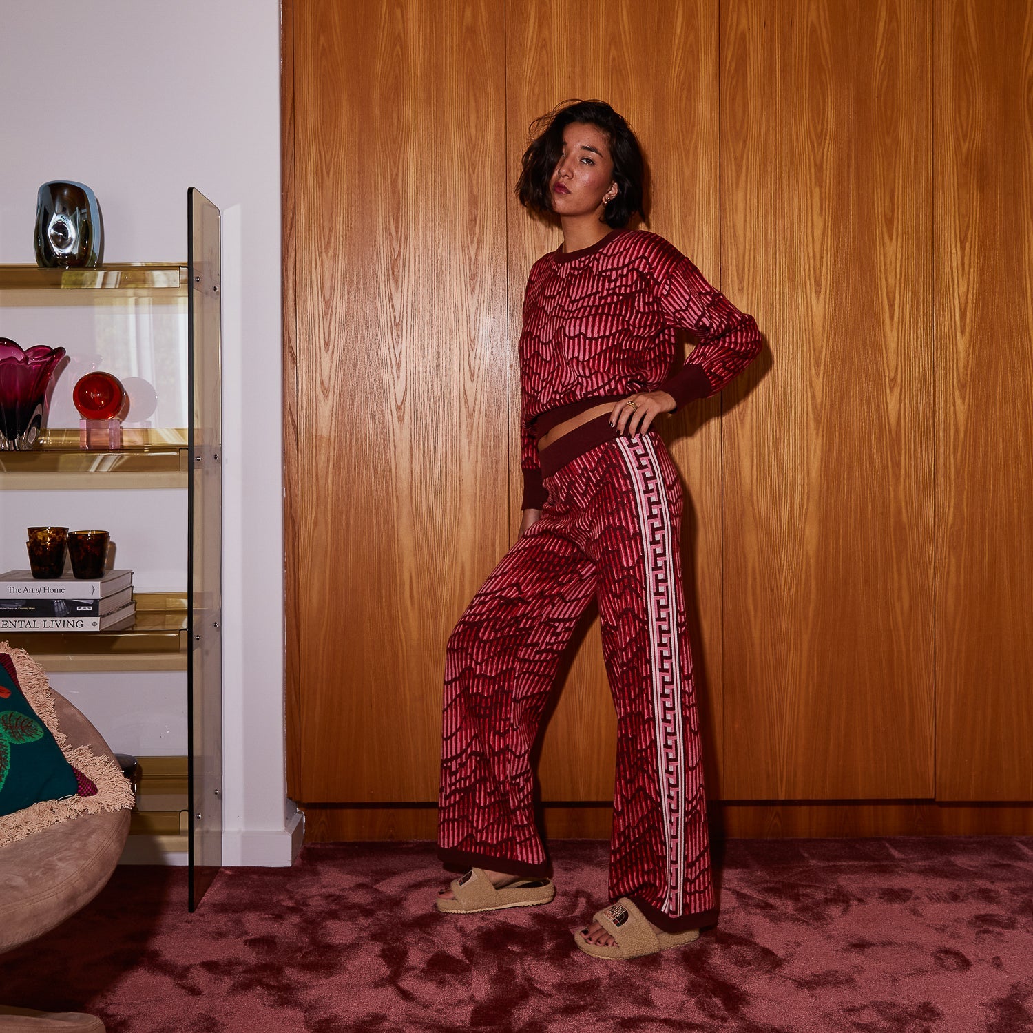 Three-quarter view of red geometric Hanna knit pants with wide leg and side stripe detail