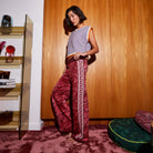 Side view of red textured Hanna knit pants with Greek key stripe and wide leg silhouette