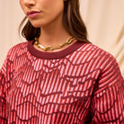 Close-up detail of Hanna Knit Sweater neckline showing red geometric pattern and ribbed trim