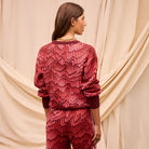 Back view of Hanna red knit sweater displaying geometric pattern and crew neck construction