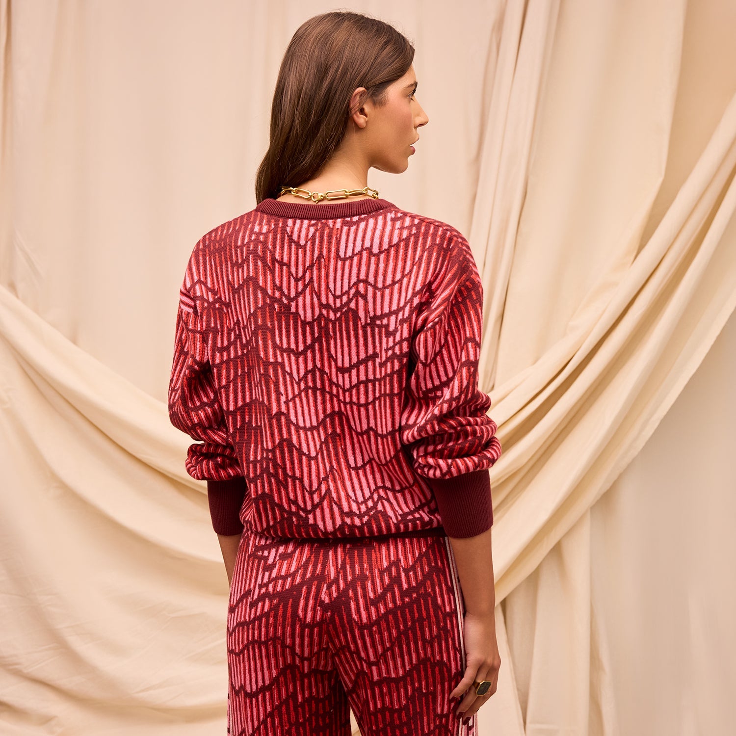 Back view of Hanna red knit sweater displaying geometric pattern and crew neck construction