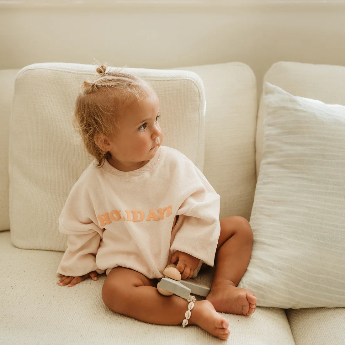 Holidays Sweater Shell by Golden Children worn by child sitting on lounge