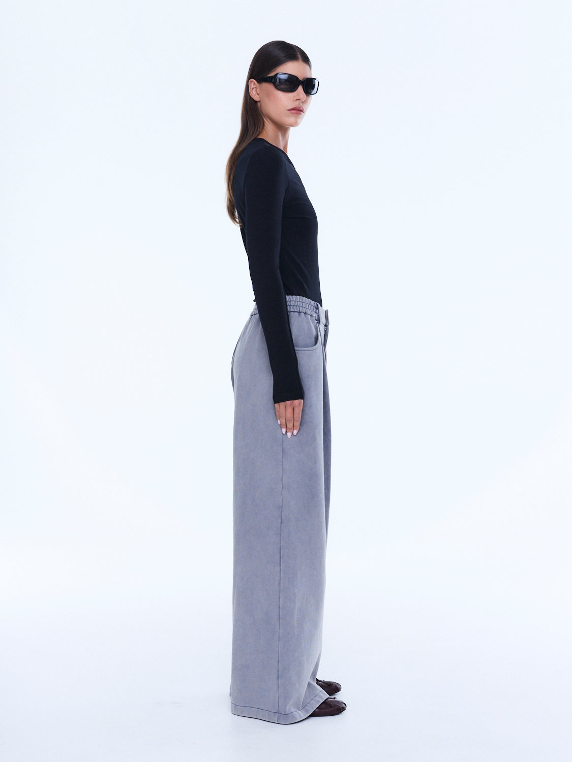 Side profile view of dove grey jersey wide leg pants showing relaxed fit and styling