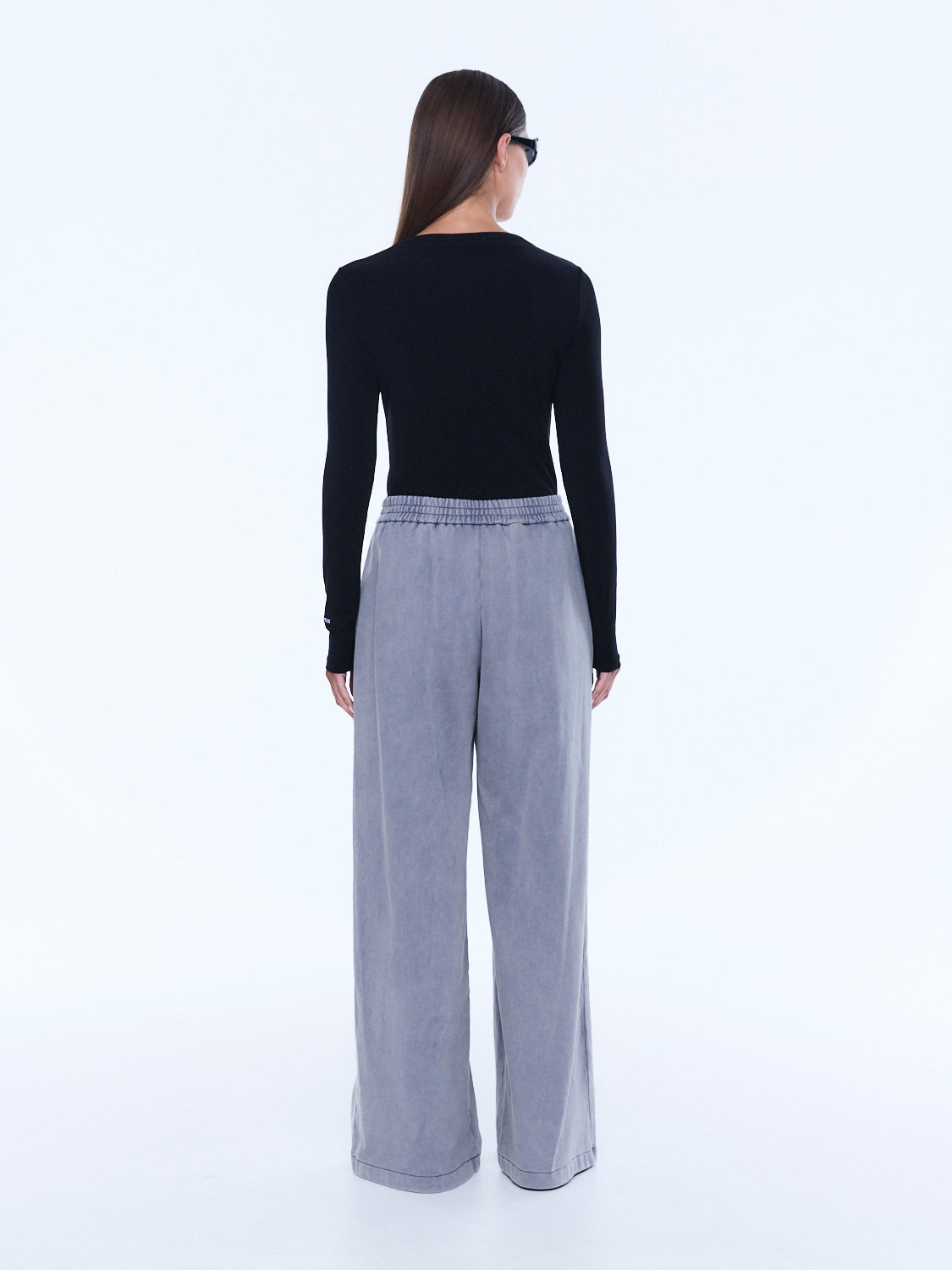 Back view of dove grey jersey wide leg pants showing elastic waistband and cuffed hem