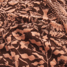 Close-up detail of the peach and dark brown botanical floral jacquard towelling fabric texture