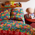 Full bedroom view of Ines Silk Pillowcase Verdant styled with coordinating duvet cover and decor accessories