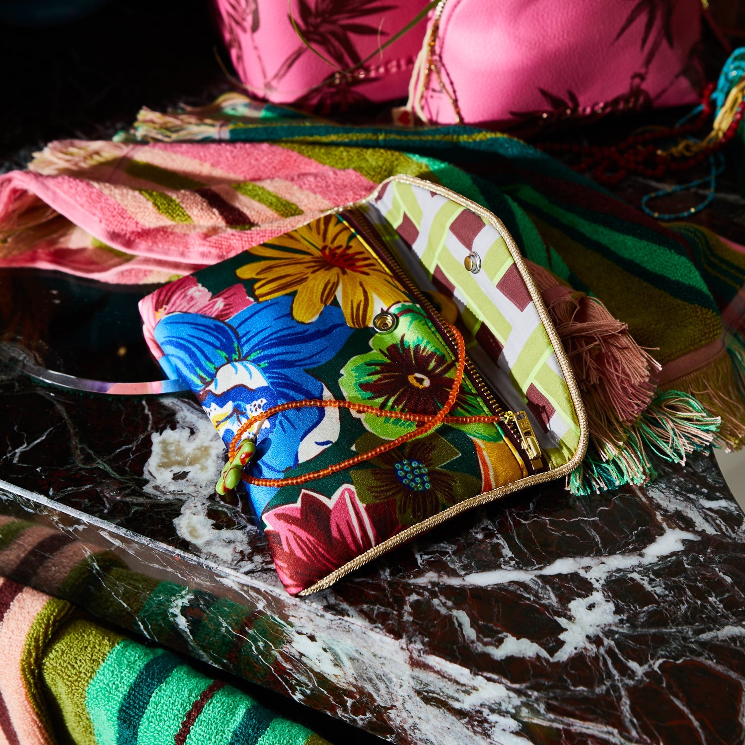 Silk Pouch Verdant with vibrant tropical floral print showing colorful flowers and gold zipper detail