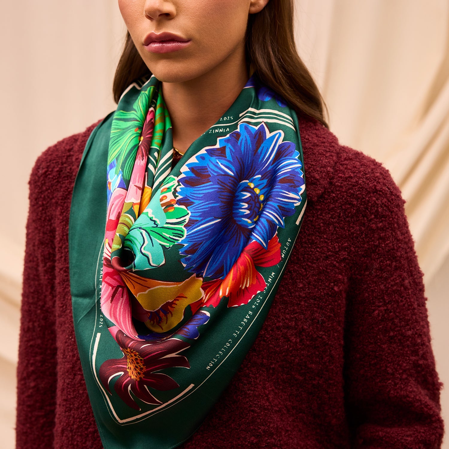 Ines Silk Scarf by Sage & Clare worn around neck showcasing vibrant tropical floral print on emerald green background