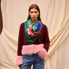 Front view of model wearing Ines Silk Scarf with colorful hibiscus and botanical motifs styled as neck accessory