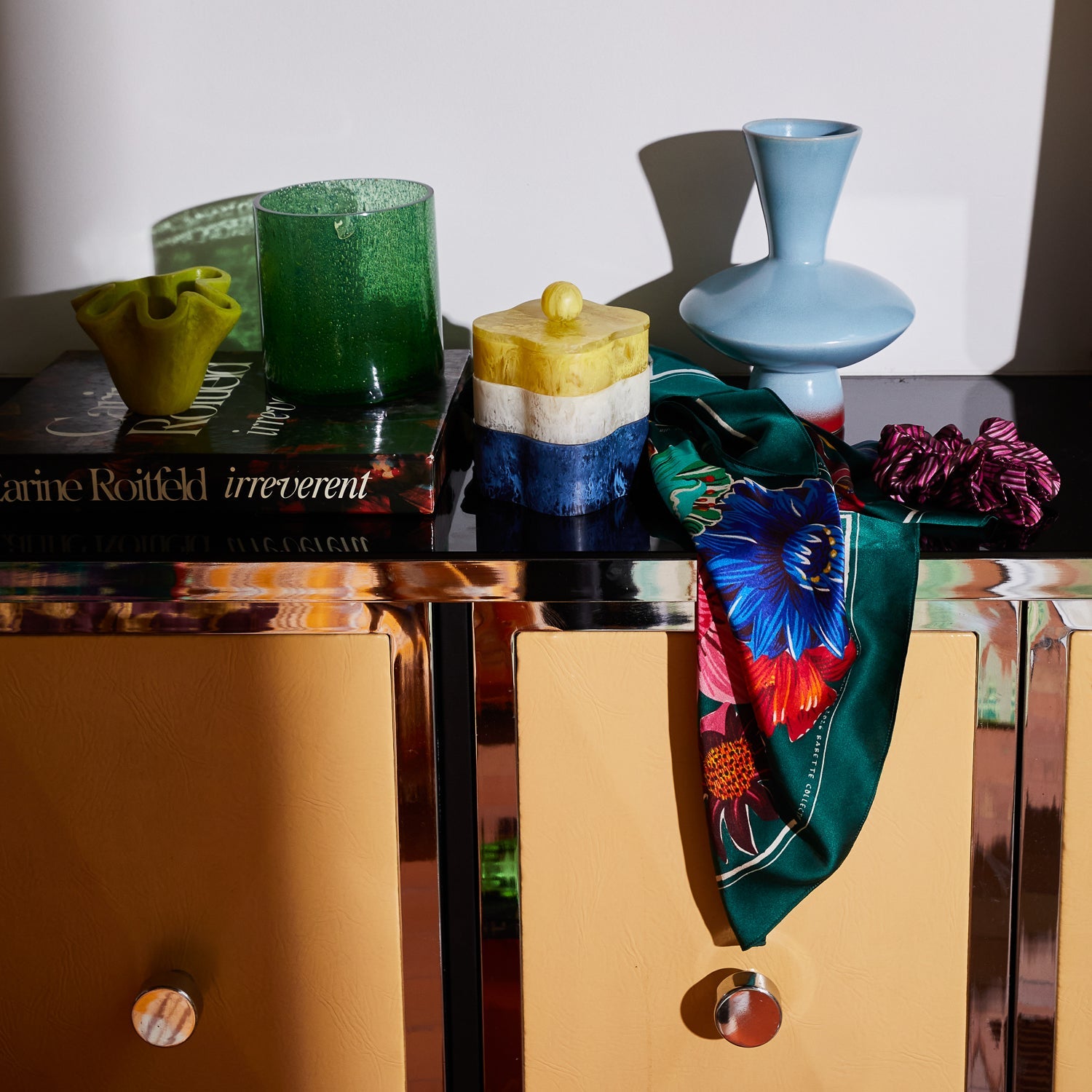 Lifestyle shot of Ines Silk Scarf draped on modern furniture with decorative objects showcasing versatile styling