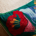 Close-up detail of red hibiscus flower on Ines Velvet Cushion showing rich velvet texture and tropical print