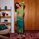 Woman wearing juniper green merino wool knit top with square neckline and flared sleeves
