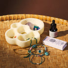 Cream multi-compartment dish styled with jewelry and crystals on woven bamboo surface
