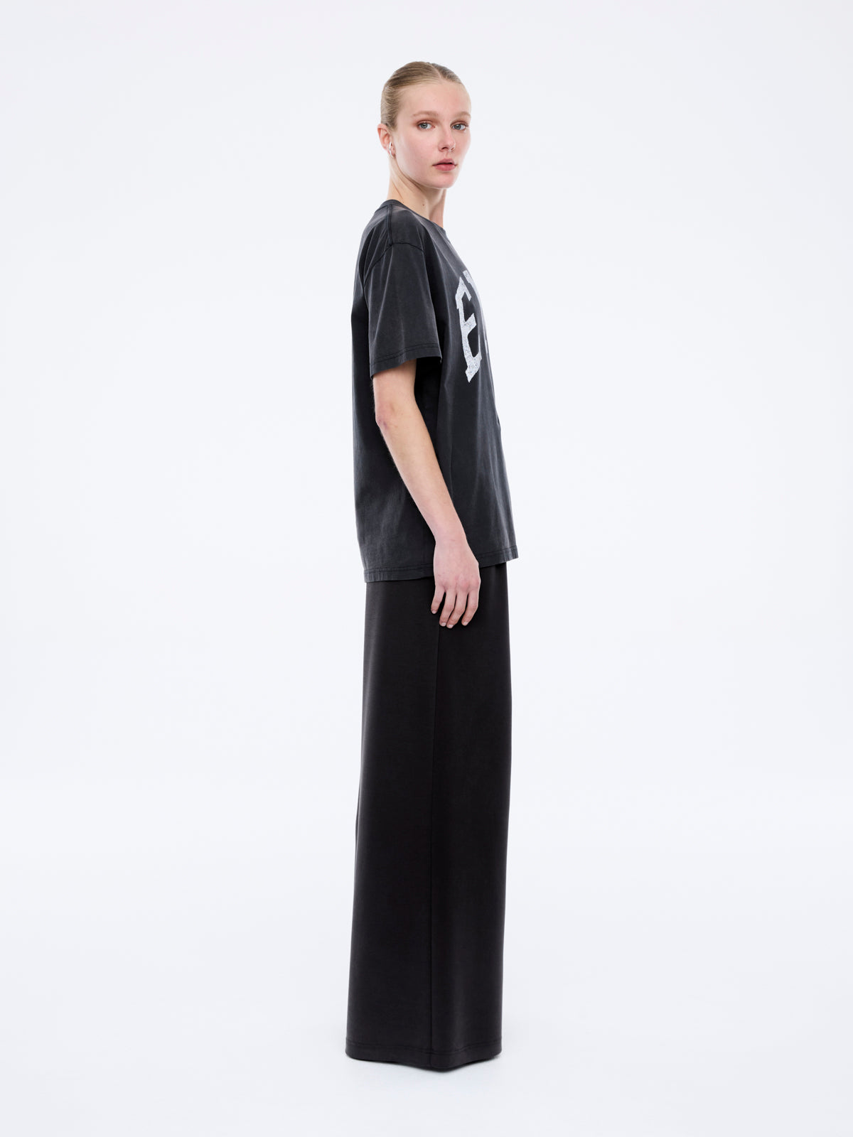 Side profile view showing oversized fit and dropped shoulders of Jessie collegiate tee in charcoal