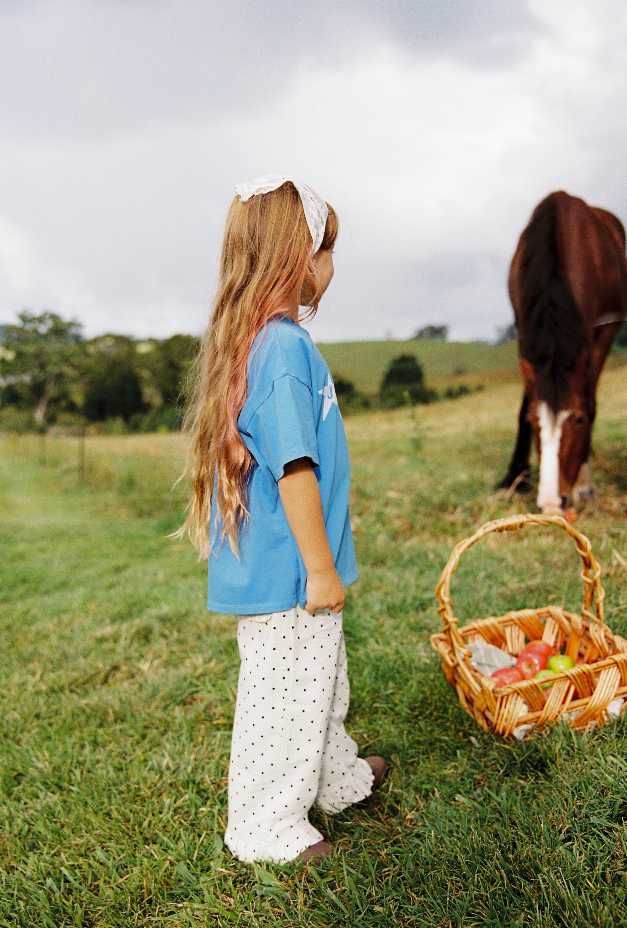 Side profile of azure blue Star Tee with white star print in outdoor setting