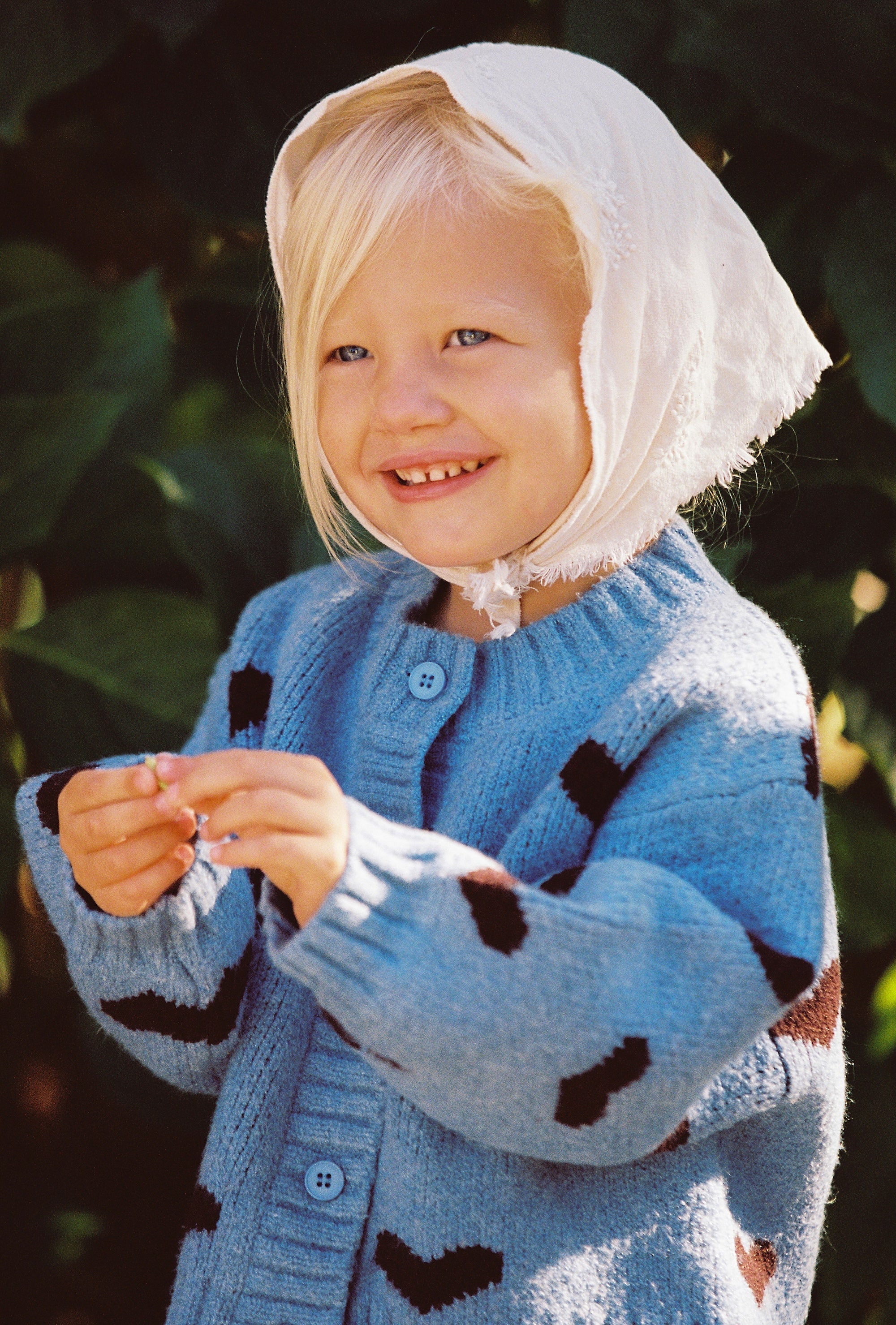 Girl wearing Juni patterned knit cardigan with heart design Australia