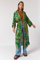 Close up detail of jade robe wide sleeves and contrast border trim