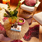 Pink marbled resin Jeanne Bowl with fruit styled on wicker coffee table in colorful boho room setting