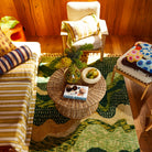 Overhead room view of cream marbled resin Jeanne Bowl with fruit on wicker coffee table in boho living room