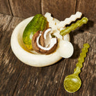 Cream white marbled resin Jeanne Bowl styled with coconut and decorative spoons on rustic wooden surface