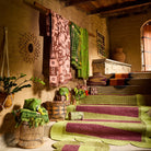 Green plaid fringed hand towel hanging on a rustic wall rack alongside other patterned towels in a boho room setting