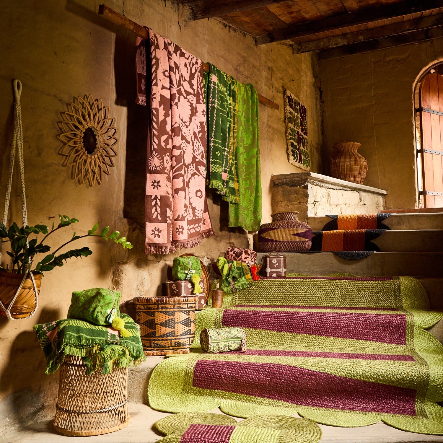Green plaid fringed hand towel hanging on a rustic wall rack alongside other patterned towels in a boho room setting